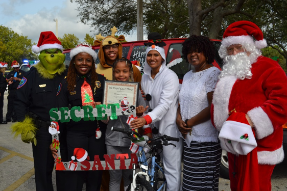 LPD Officers wearing holiday customs with community members during the Secret Santa event