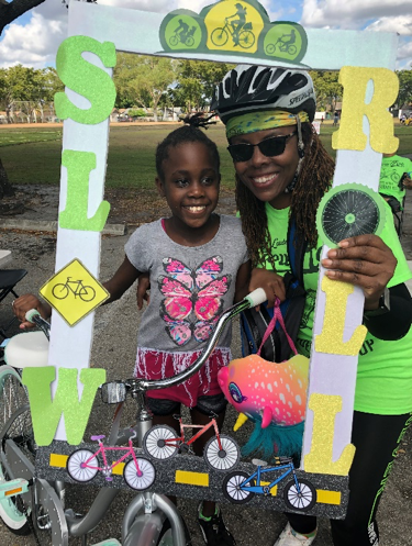 Chief Constance Y. Stanley and participating kid smiling together with a Slow Roll frame at the event