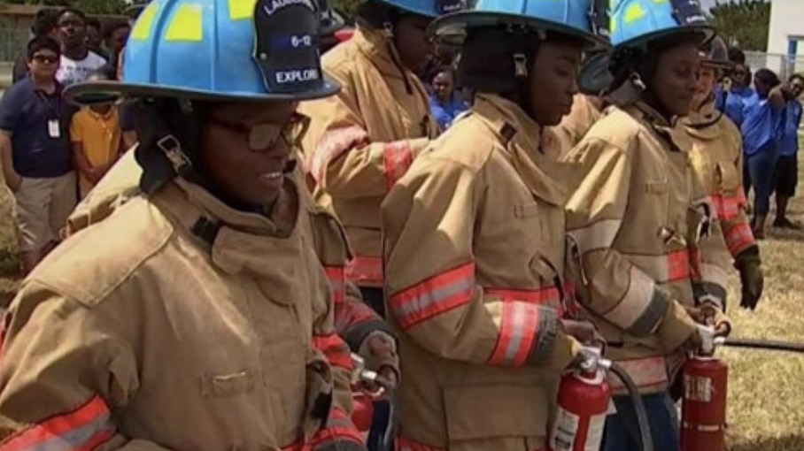 Lauderhill 6-12 Students training in fire uniforms with fire extinguishers