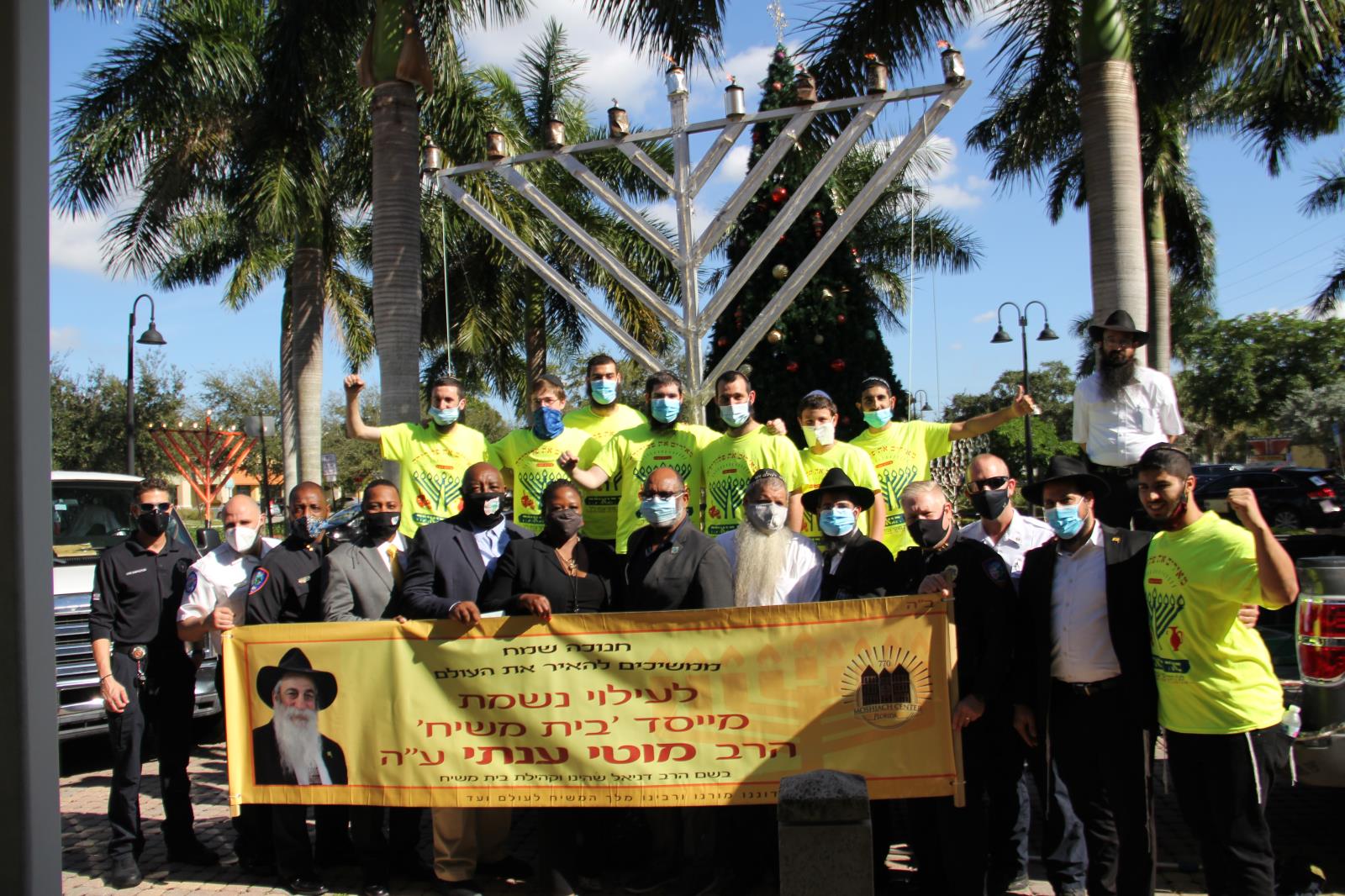 City of Lauderhill officials students and teachers of 770 moshiach center in front of menorah outdoors