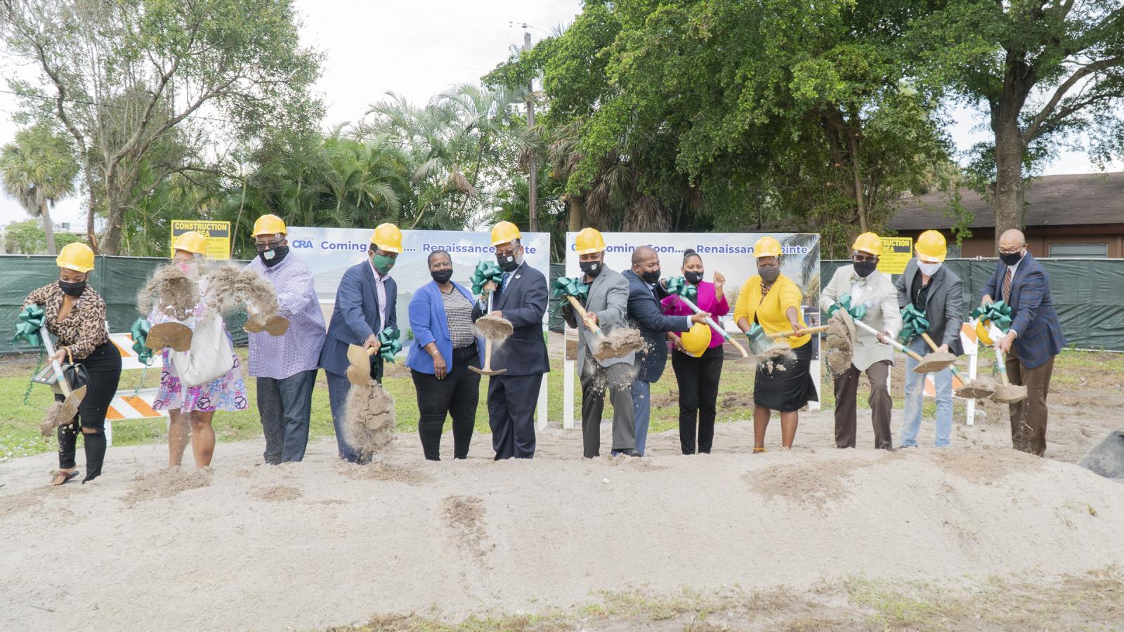 Renaissance Point project participants shovel dirt in a cleared lot