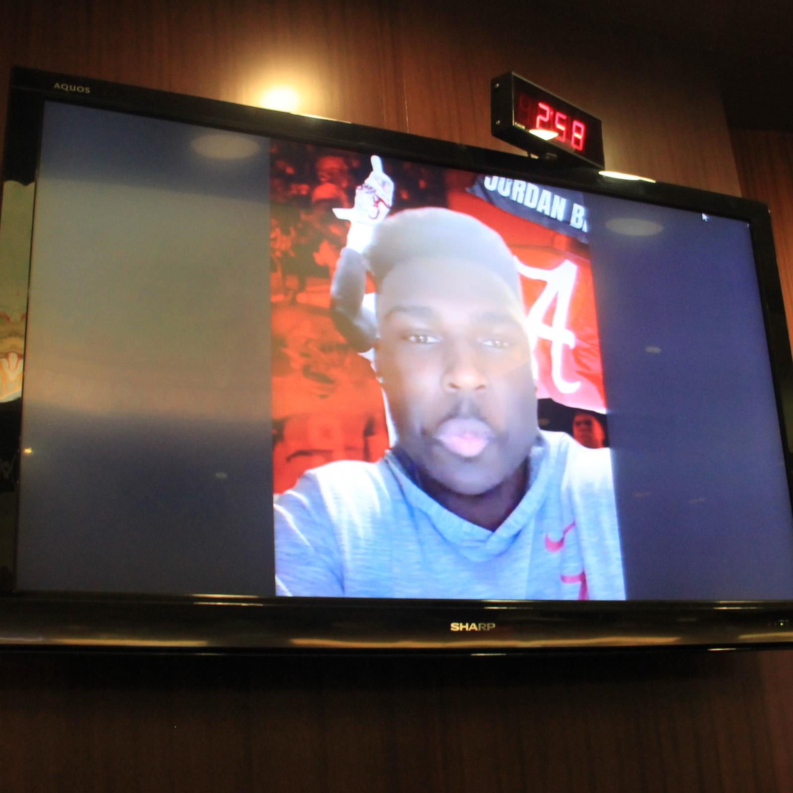 Jordan battle on tv monitor with University of Alabama logo as background