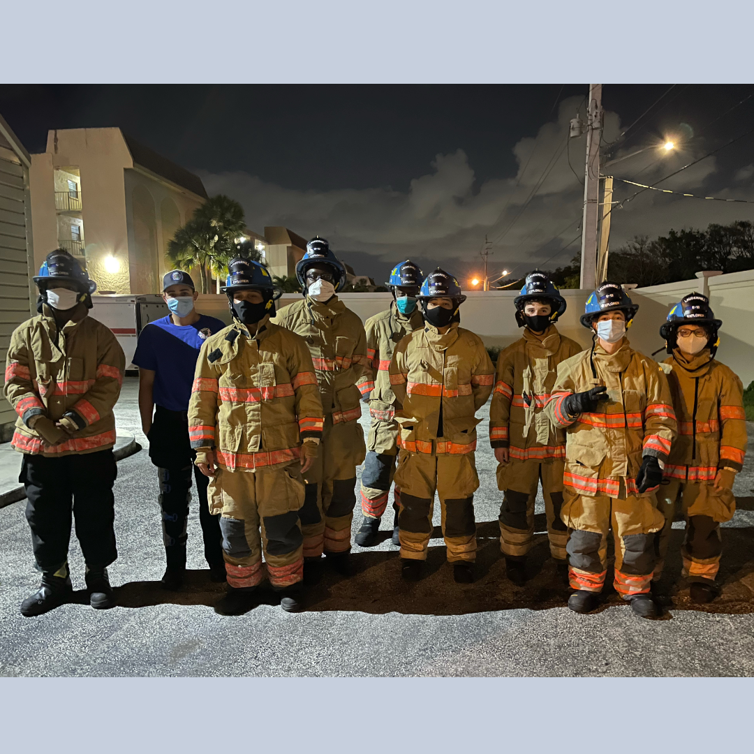 Lauderhill fire explorers in firefighter uniforms at night in a parking lot