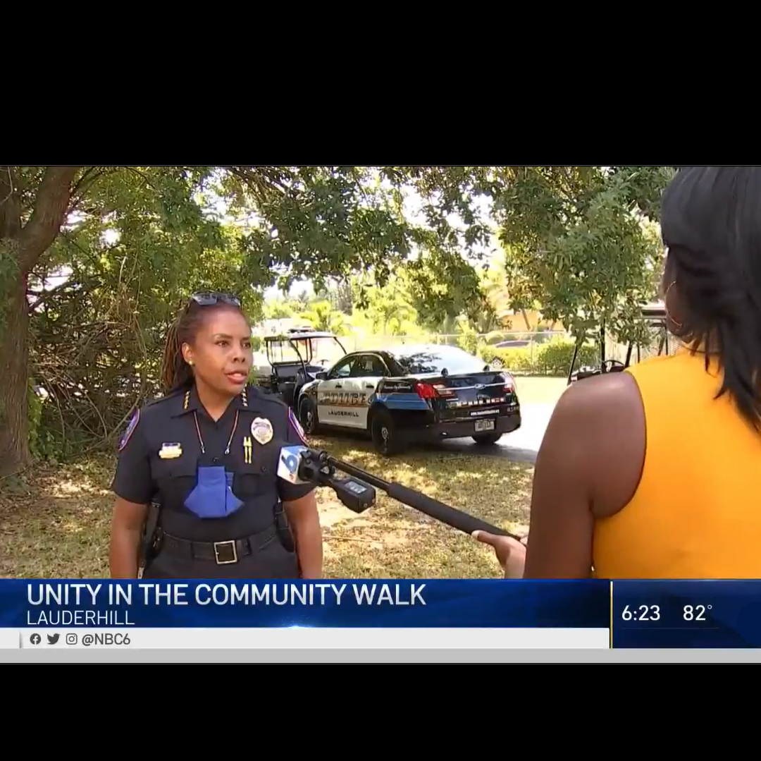 Still image of nbc 6 filmed interview of chief Stanley outdoors in parking lot with chyron unity in the community walk Lauderhill and news anchor