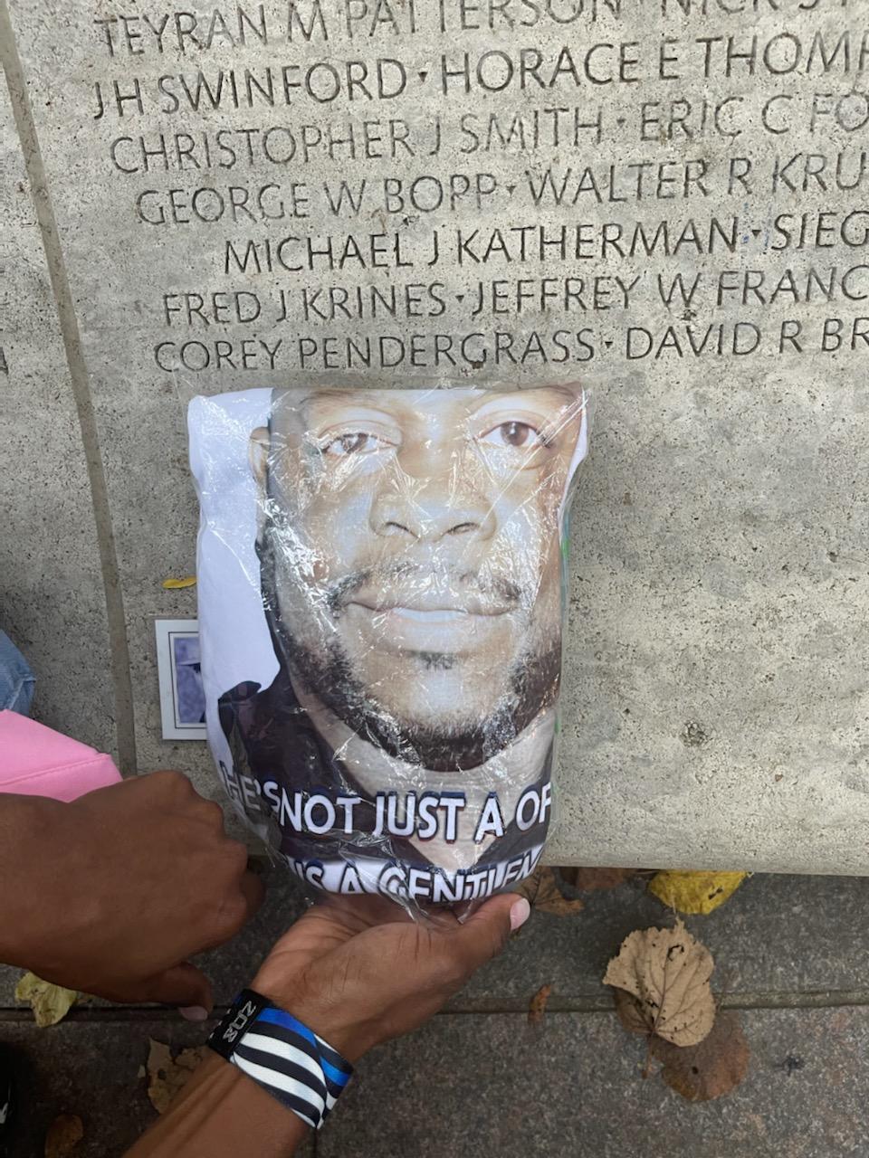 corey pendergrass' picture is held up to his engraved name on a slab