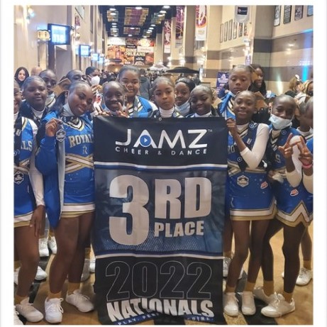 royals cheerleaders hold third place banner indoors